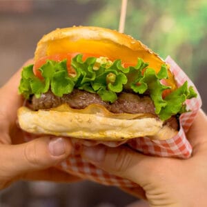 Hamburger con lattuga, pomodoro e carne alla griglia in panino con sesamo
