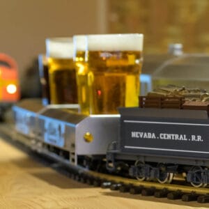 Modellino di treno Nevada Central R.R. che trasporta bicchieri di birra lungo i binari del ristorante