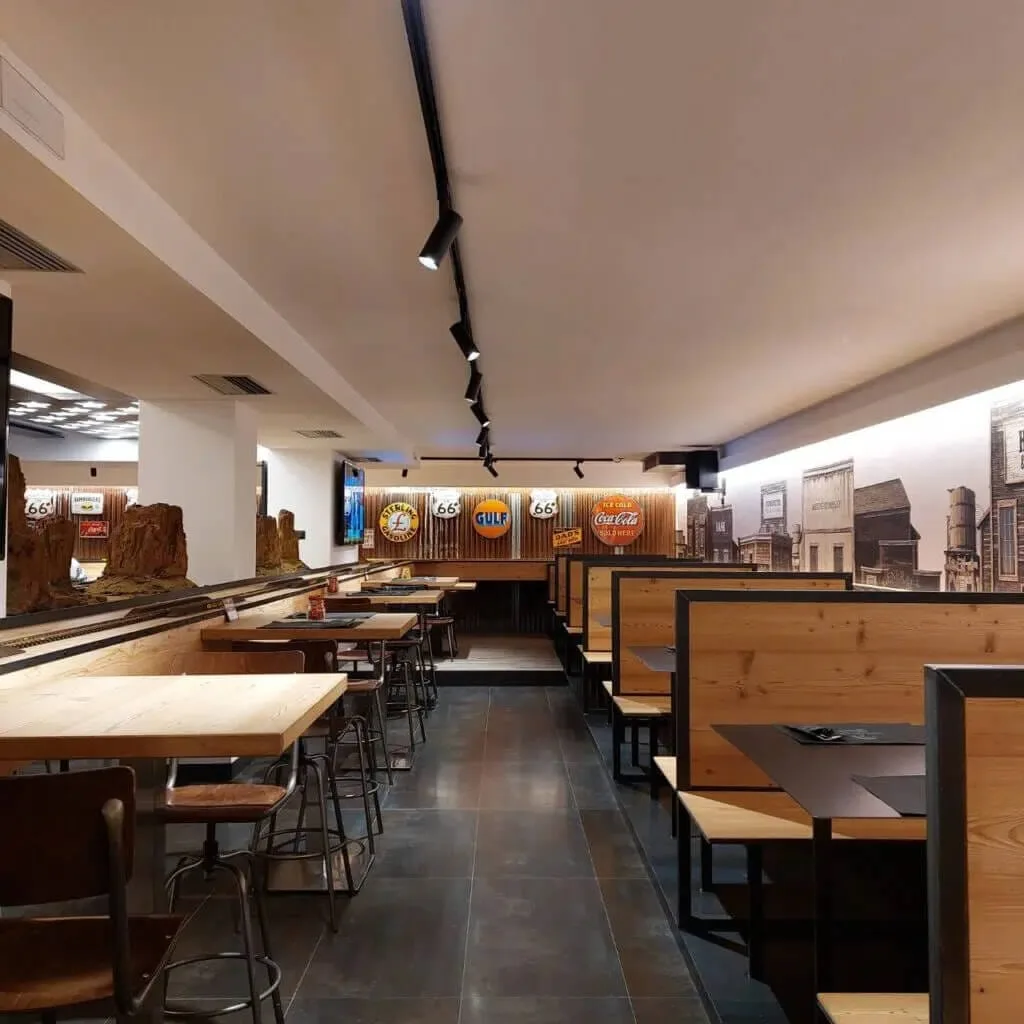 Interni del ristorante in stile americano con tavoli in legno, sedute imbottite e decorazioni vintage